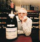Photograph of Trevor Hughes with a magnum bottle.